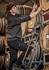 A person in a dark grey unisex water-resistant hoodie climbing a ladder among wine barrels. The hoodie has a logo.