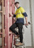 A pair of lightweight black cargo pants worn by a man on a ladder, paired with a yellow and navy shirt and work boots.