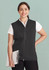 A black zip-front vest designed for women, featuring a logo, worn over a white shirt.
