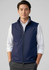A navy blue men's softshell vest features a zip front and a collar, worn over a white shirt. It has a logo on the chest.