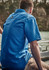 A blue men's short sleeve outdoor shirt featuring a logo, designed for comfort and activity.