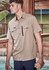 A tan short sleeve button-up shirt with two front pockets and a zip pocket, worn by a male model.