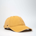 A cotton canvas unstructured six-panel cap in a mustard yellow colour, featuring a small logo on the side.