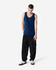 A unisex fine jersey tank in navy, paired with black pants and sneakers, featuring a logo on the tank.