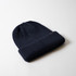 A navy knitted beanie with a folded cuff and a logo on the side.