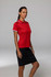 A red polo shirt with contrasting white trim, modelled by a woman in a skirt. The shirt features a logo.