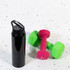 A drink bottle in black with a flip straw lid, positioned next to bright green and pink dumbbells.