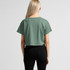 A cropped green T-shirt with short sleeves, viewed from the back, accompanied by black jeans. Features a logo.