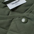 A quilted jacket in olive green with a button and a tag featuring a logo.