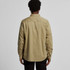 A button-up shirt in khaki with a classic collar and long sleeves. The shirt features a branding logo.