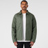 A green service jacket with a collared neck and a zip front, worn over a white t-shirt, displayed against a neutral background.
