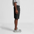 A pair of black sports shorts with a drawstring waist, shown on a model from the side. The model is wearing grey sneakers.