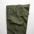 Utility cargo pants in olive green, featuring side and back pockets, laid flat against a white background.