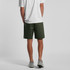 A person wearing green walk shorts, viewed from the back, paired with a white t-shirt and grey shoes.
