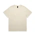 A cream-coloured t-shirt featuring a relaxed fit design and a brand label on the neckline.