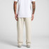 Cuffless track pants in a light cream colour, displaying a relaxed fit from the back view. Features branding.