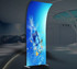 A tension fabric display featuring a vibrant blue design with a water bottle and splashes, set in a modern indoor space.