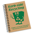 Aspiral-bound A5 notebook with a brown cover featuring a green recycling character and a logo.