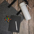 A grey tote bag, white drink bottle, black notebook, and a pen with colourful candies in a container.