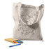 A beige tote bag featuring a colouring design, with a box of colourful crayons beside it.