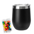 A reusable black coffee cup with a silver lid, accompanied by a packet of colourful jelly beans.