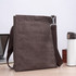 A brown nylon library bag with a shoulder strap, placed next to a laptop and a drink bottle on a table.