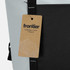 A light blue and black cooler totpack featuring a tag with a logo and an illustration of mountains.