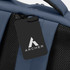 A blue soft-touch daily backpack featuring a mesh panel and a branded tag.