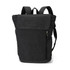 A black canvas backpack featuring adjustable straps, a front zip pocket, and a flap closure. It has a logo detail.