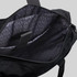 A black tote pack with an interior featuring a patterned lining and multiple compartments. It has a logo on the exterior.
