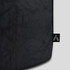 A black duffle bag with a textured design and a logo tag on the side.