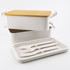 A dual-compartment lunch box with a yellow lid, featuring white utensils and an inner tray. It has a logo on the side.