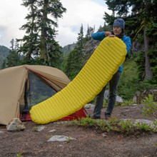 in use shot of a yellow lightweight, insulated air, comfortable, warm, sleeping pad, being used for tent camping in the mountains