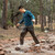 in use photo of a person utilizing their light weight wind pants while crossing a small stream