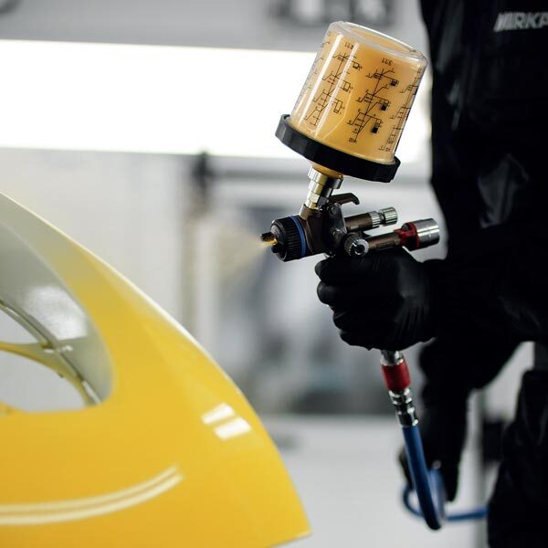 HVLP spray gun painting yellow automotive surface
