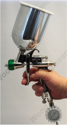 Person holding a gravity feed spray gun