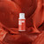 Bottle of Colour Mill Oil Base colour Sunset above sugarpaste coloured in Colour Mill Oil base Sunset