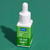 bottle of green colour drops with green background