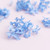 light blue dried hydrangea flowers scattered on a pink background