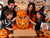 Family opening a Pumpkin Patch Treats Halloween gift basket filled with treats during a Halloween celebration