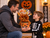 Father giving Happy Halloween Haul 8-inch pumpkin gift basket to his son at a Halloween birthday celebration