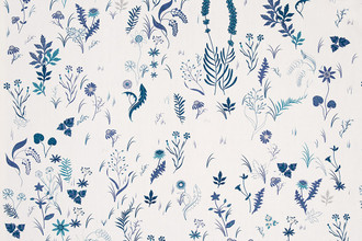 Deep indigo botanical fabric on white linen cloth, showcasing intricate garden-inspired illustrations by designer Tord Boontje.