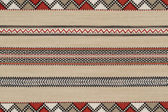 Woven fabric in red, navy and natural tones. Has zig zag motif stripes running horizonal.