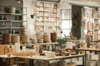 Vorster & Braye Ceramic Studio – a table filled with clay pots and tools, showcasing a creative workspace in the midst of artistic production and craftsmanship.