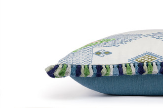 Side view of Travelling Light Teal cushion featuring vibrant teal woven Nola fabric for back and teal, green, yellow and orange colours on the front, finished with green Jamboree fringe trim.