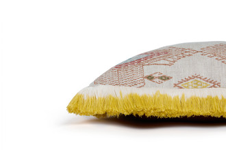 Side view of Travelling Light Terracotta cushion showing the patterned front, terracotta Nola woven back, and lemon-yellow ombre fringed trim along the edge.