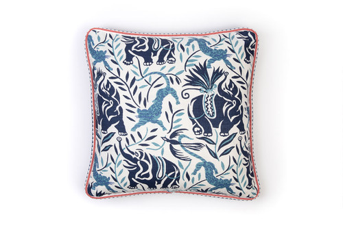 La Jungle Cushion in Dark Indigo – showcasing Raoul Dufy’s elephant and leopard motifs in tonal blues, with bold red Pyramid piping that adds a striking contrast.
