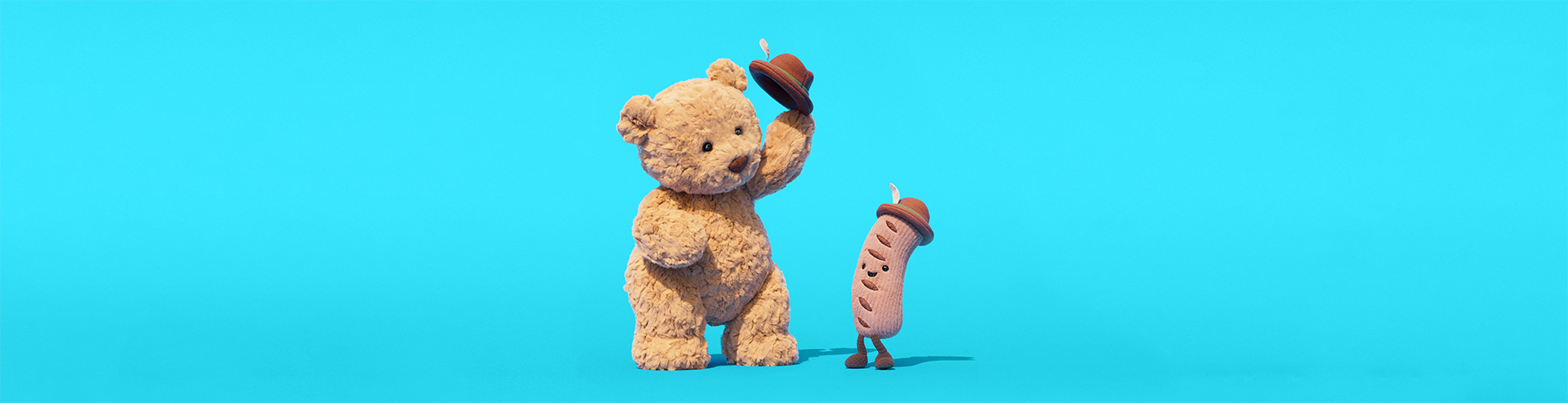 Bartholomew Bear hebt seinen Hut vor einer Jellycat-Wurst, die ebenfalls einen Hut trägt.