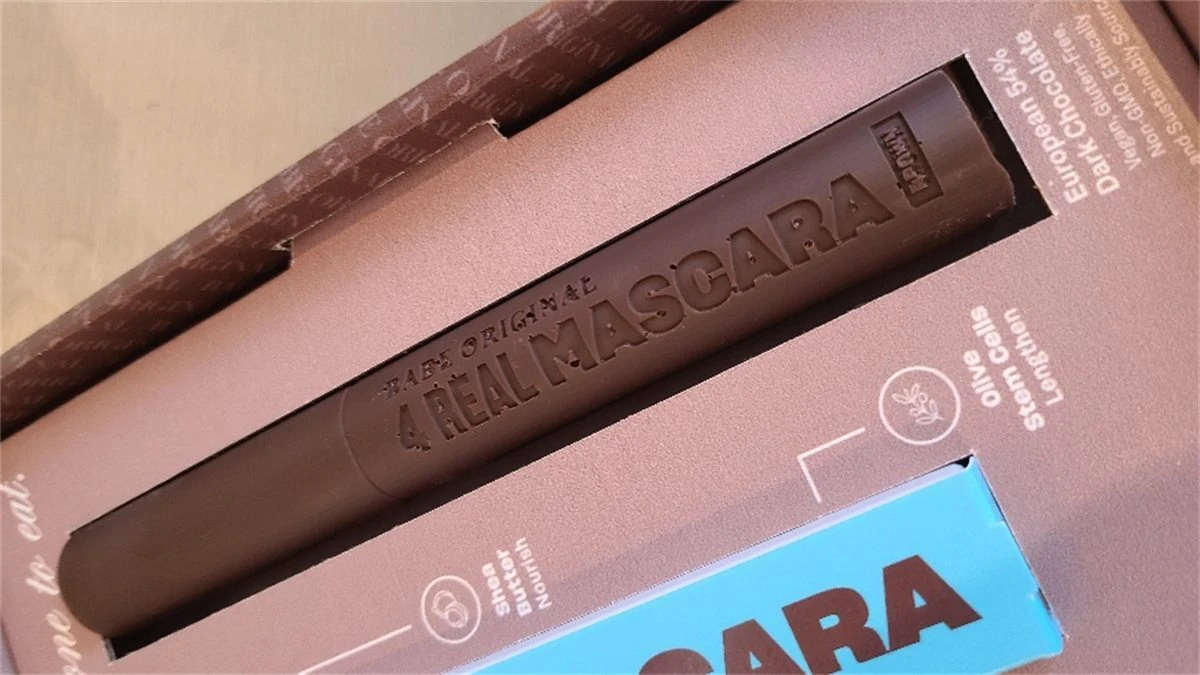 Chocolate replica of a branded mascara tube beside matching chocolate bars