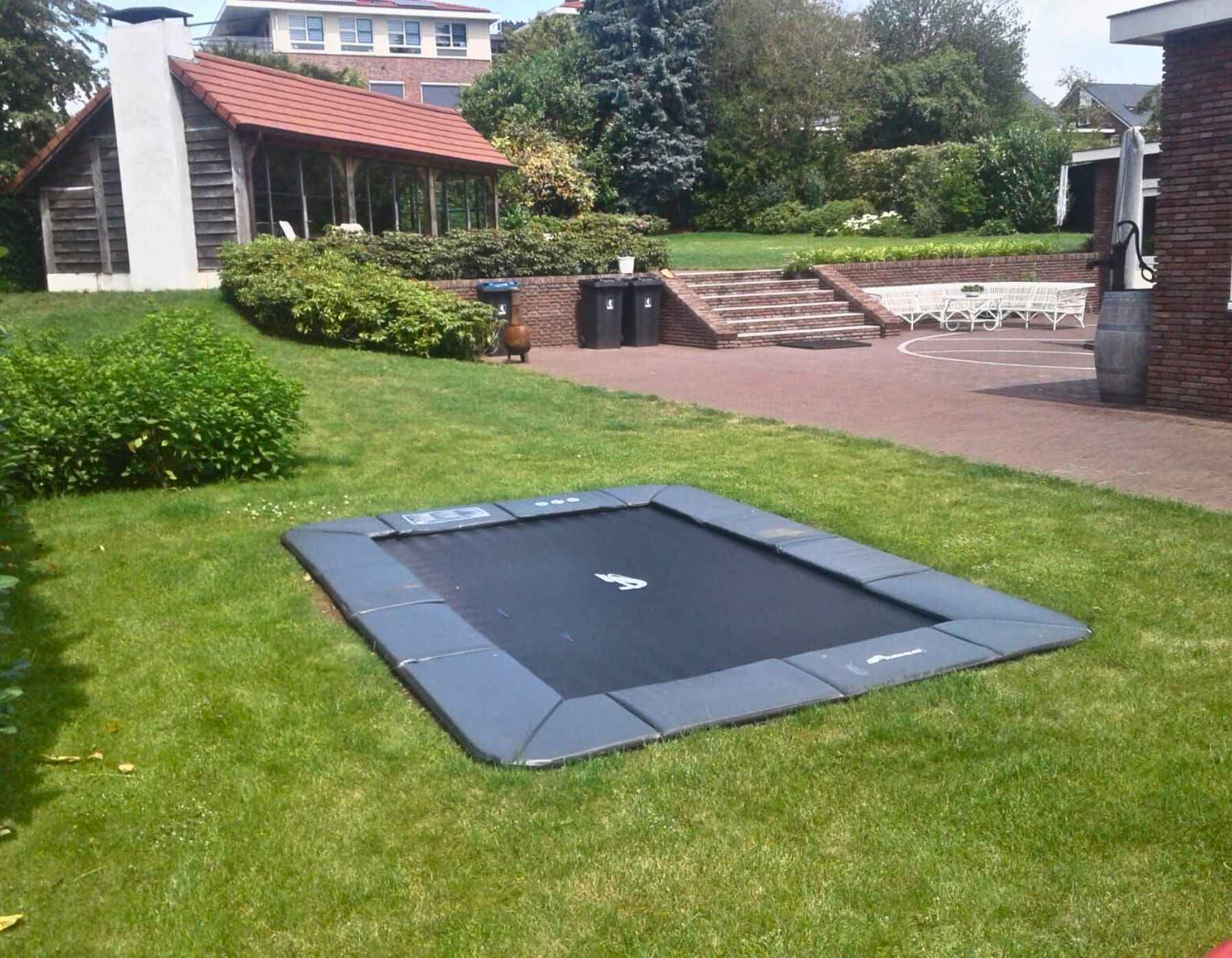 Akrobat Orbit Flat rectangular flush-to-ground trampoline with anthracite safety pad at a customer installation